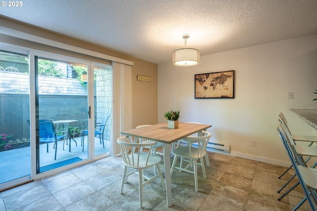 dining space with baseboards, a textured ceiling, and a baseboard heating unit