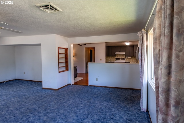 47508 Hansen St, Oakridge, OR 97463 - unfurnished living room featuring ceiling fan, carpet flooring, baseboards, and a textured ceiling