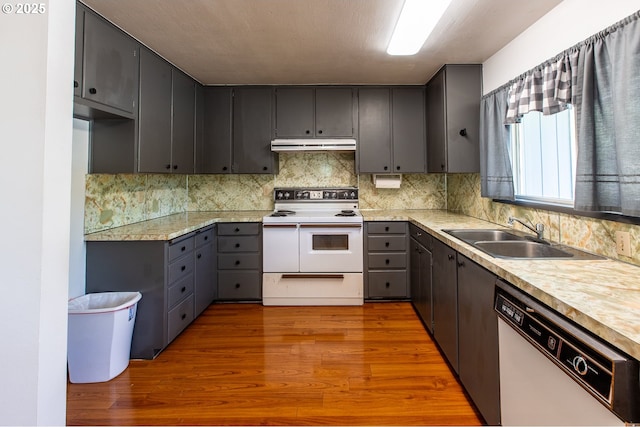 47508 Hansen St, Oakridge, OR 97463 - kitchen featuring white appliances, a sink, under cabinet range hood, decorative backsplash, and dark wood-type flooring