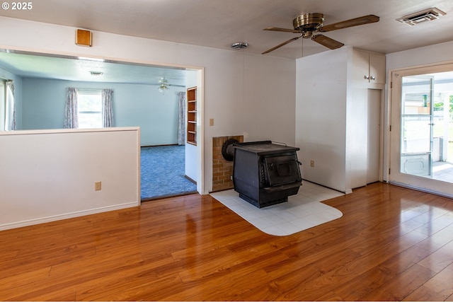 47508 Hansen St, Oakridge, OR 97463 - unfurnished living room with a wood stove, ceiling fan, and wood finished floors
