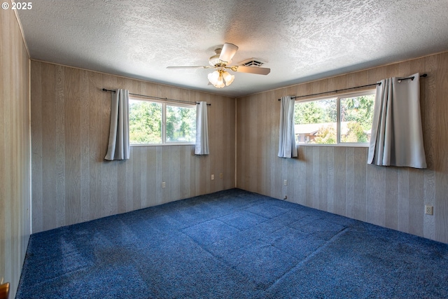 47508 Hansen St, Oakridge, OR 97463 - carpeted empty room featuring wooden walls, a ceiling fan, and a textured ceiling