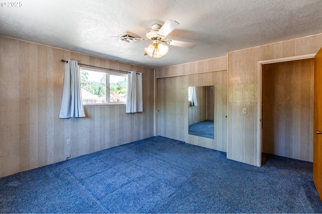 47508 Hansen St, Oakridge, OR 97463 - unfurnished bedroom with carpet flooring, a textured ceiling, wooden walls, and ceiling fan