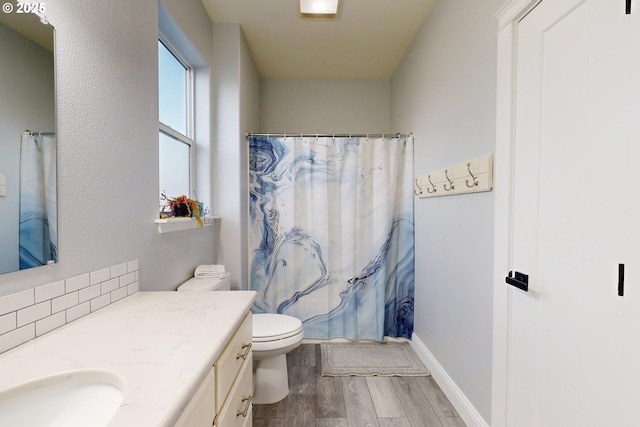 bathroom with walk in shower, wood-type flooring, toilet, and vanity