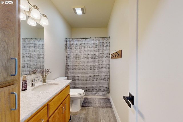 bathroom featuring vanity, toilet, curtained shower, and hardwood / wood-style floors