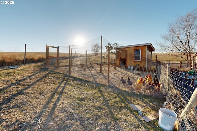 view of yard featuring an outdoor structure and a rural view