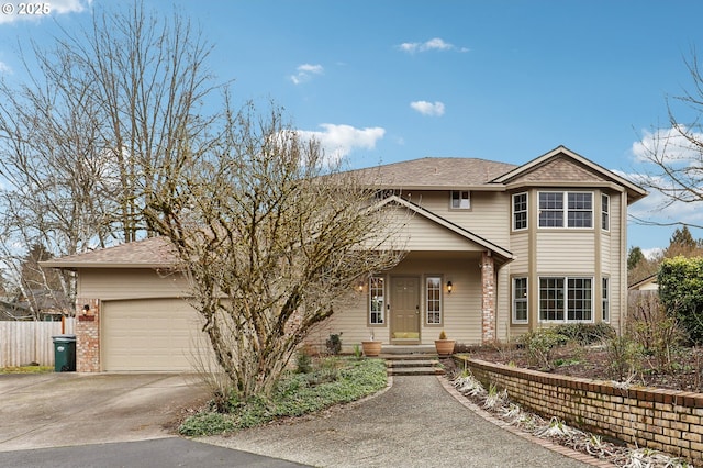 traditional-style house featuring a garage, fence, concrete driveway, and brick siding