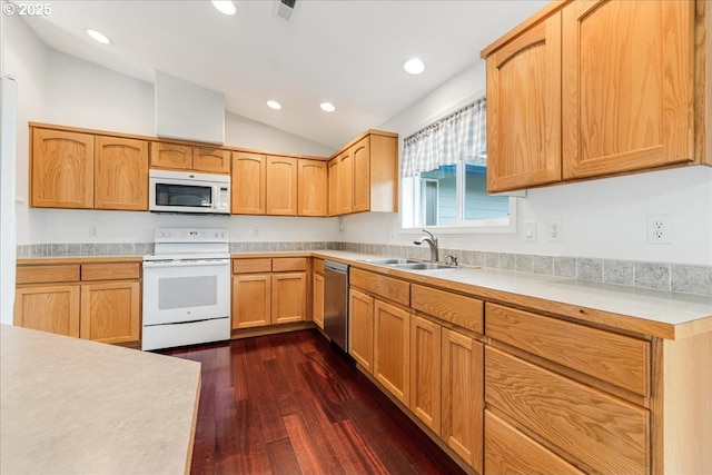 kitchen featuring vaulted ceiling, white appliances, dark hardwood / wood-style floors, and sink