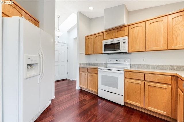 kitchen with white appliances, dark hardwood / wood-style flooring, hanging light fixtures, and a towering ceiling