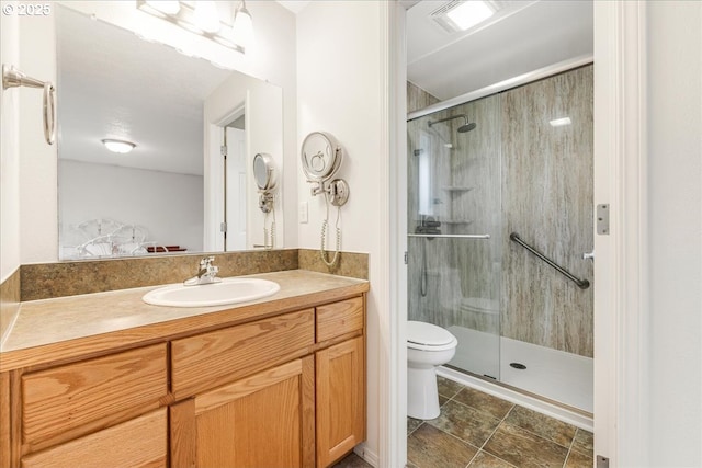 bathroom with vanity, a shower with door, and toilet