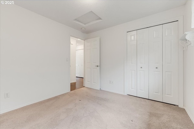 unfurnished bedroom with light carpet and a closet