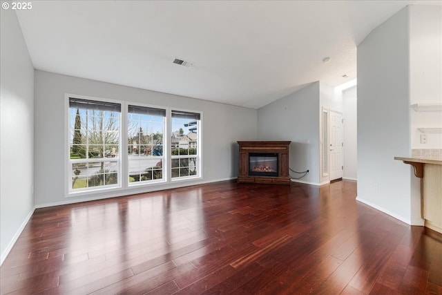 unfurnished living room featuring lofted ceiling and dark hardwood / wood-style flooring