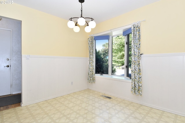 4296 SE Fieldcrest St, Milwaukie, OR 97222 - spare room featuring wainscoting, healthy amount of natural light, tile patterned floors, a chandelier, and a decorative wall