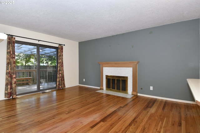 4296 SE Fieldcrest St, Milwaukie, OR 97222 - unfurnished living room featuring wood finished floors, a textured ceiling, and a fireplace
