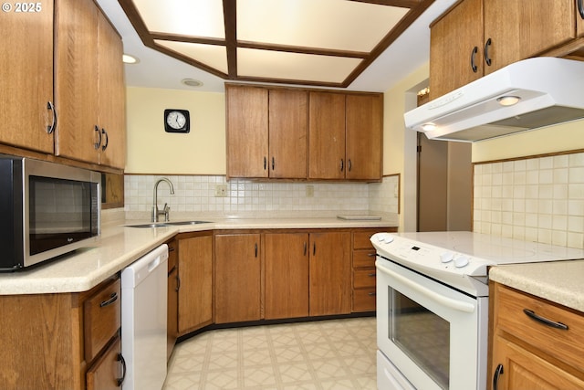 4296 SE Fieldcrest St, Milwaukie, OR 97222 - kitchen with white appliances, under cabinet range hood, light countertops, and brown cabinetry