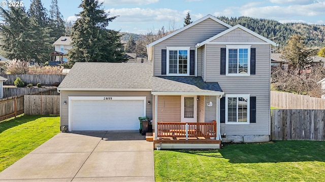 traditional home with an attached garage, driveway, a front lawn, and fence