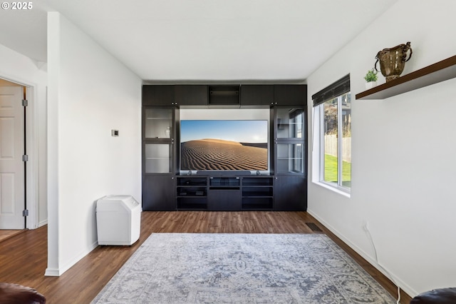 living area featuring visible vents, baseboards, and wood finished floors