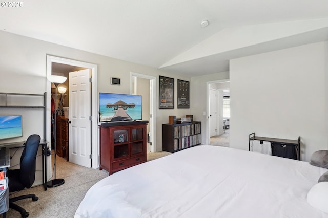 bedroom with lofted ceiling and light colored carpet