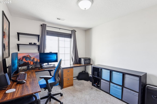 carpeted office space featuring visible vents and a textured ceiling