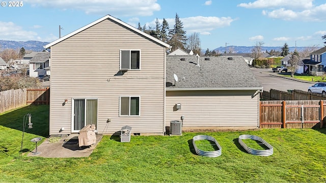 back of house with a fenced backyard, cooling unit, a yard, a patio area, and a mountain view