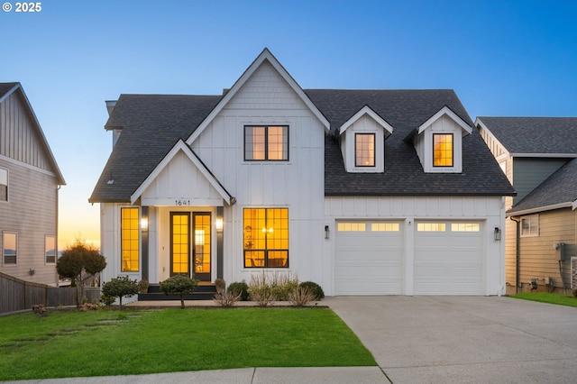 modern farmhouse featuring roof with shingles, a front lawn, board and batten siding, and driveway