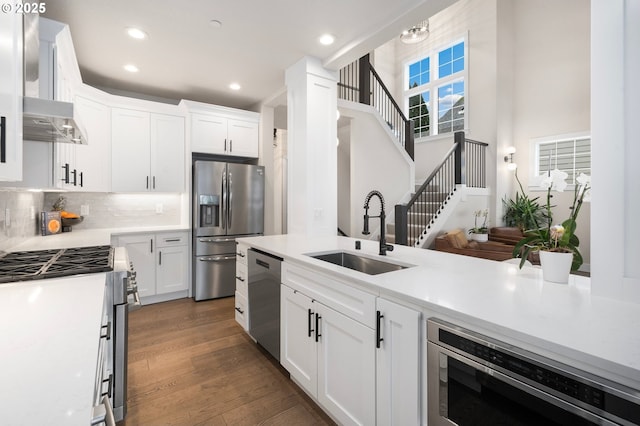 kitchen with dark wood finished floors, light countertops, appliances with stainless steel finishes, white cabinetry, and a sink