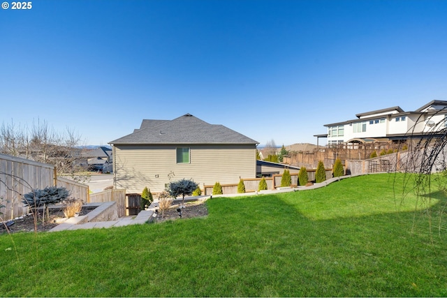 rear view of property featuring a fenced backyard and a yard