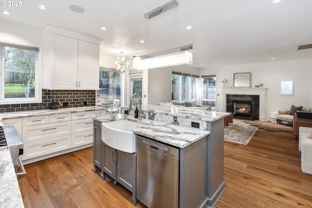 kitchen featuring open floor plan, light wood-style flooring, dishwasher, and visible vents