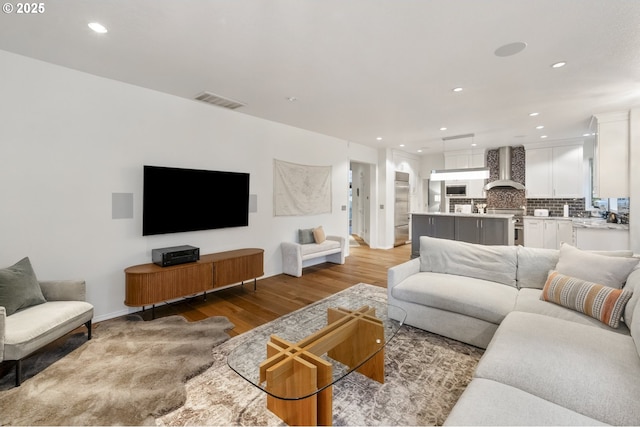 living room featuring recessed lighting, visible vents, baseboards, and light wood finished floors