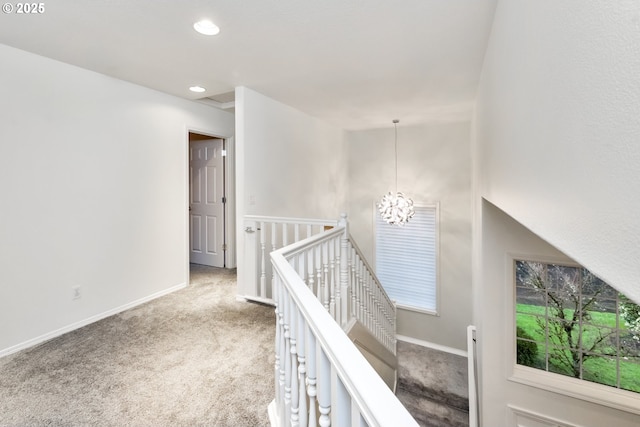 hallway featuring an upstairs landing, recessed lighting, an inviting chandelier, carpet flooring, and baseboards