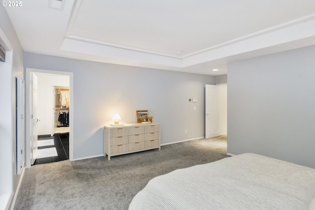 bedroom featuring a tray ceiling, carpet flooring, visible vents, and baseboards