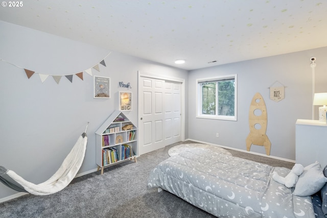 carpeted bedroom with a closet and baseboards