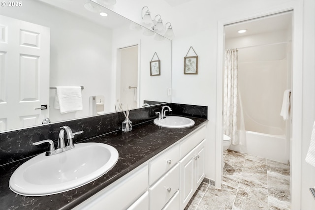 bathroom featuring double vanity, toilet, shower / bath combo, and a sink