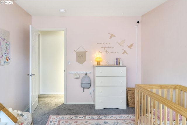 carpeted bedroom with a nursery area and baseboards