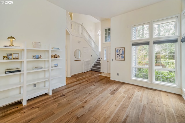 foyer featuring a wealth of natural light, stairs, and hardwood / wood-style flooring