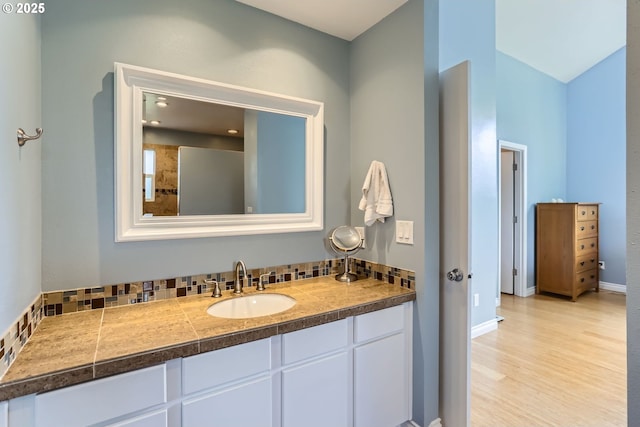 1543 NE Hyde St, Hillsboro, OR 97124 - bathroom with vanity, decorative backsplash, baseboards, and wood finished floors