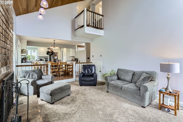 1543 NE Hyde St, Hillsboro, OR 97124 - carpeted living room with high vaulted ceiling, a brick fireplace, baseboards, and a chandelier