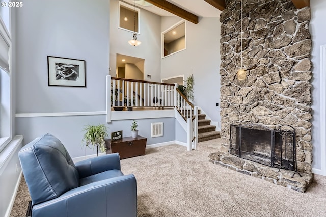 1543 NE Hyde St, Hillsboro, OR 97124 - carpeted living room with high vaulted ceiling, beam ceiling, stairs, a stone fireplace, and baseboards