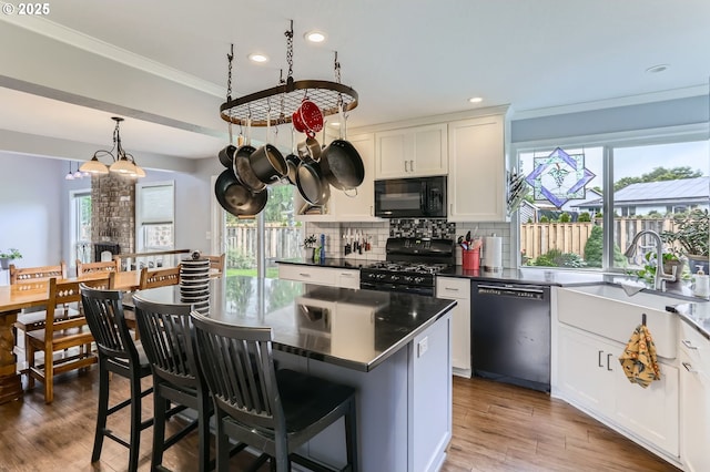 1543 NE Hyde St, Hillsboro, OR 97124 - kitchen with black appliances, white cabinetry, a kitchen island, decorative backsplash, and recessed lighting