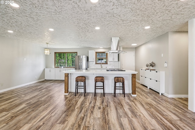 1213 NW Westridge St, Vancouver, WA 98665 - kitchen featuring freestanding refrigerator, island range hood, a kitchen island, wood finished floors, and recessed lighting