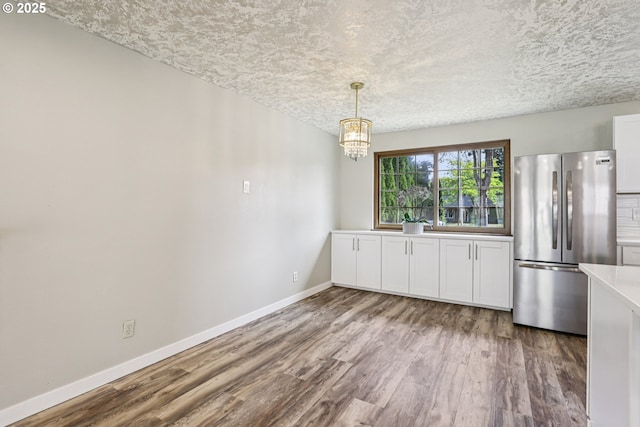 1213 NW Westridge St, Vancouver, WA 98665 - unfurnished dining area featuring wood finished floors, a chandelier, and a textured ceiling