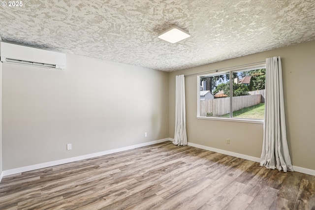 1213 NW Westridge St, Vancouver, WA 98665 - spare room featuring an AC wall unit, wood finished floors, and a textured ceiling