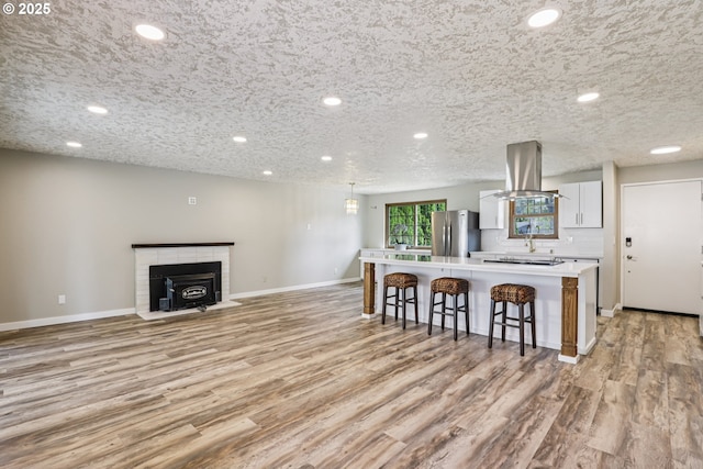 1213 NW Westridge St, Vancouver, WA 98665 - kitchen with island range hood, freestanding refrigerator, a kitchen bar, a center island, and light wood-style floors