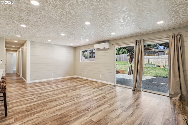 1213 NW Westridge St, Vancouver, WA 98665 - unfurnished living room with a wall mounted air conditioner, wood finished floors, recessed lighting, and wooden walls