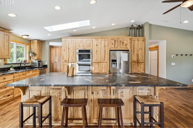 40774 SE Trubel Rd, Sandy, OR 97055 - kitchen featuring appliances with stainless steel finishes, vaulted ceiling, a skylight, a spacious island, and recessed lighting