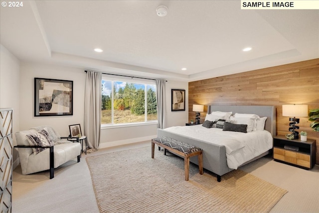 carpeted bedroom with a tray ceiling and wood walls