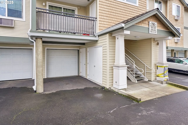 entrance to property featuring a garage and a balcony