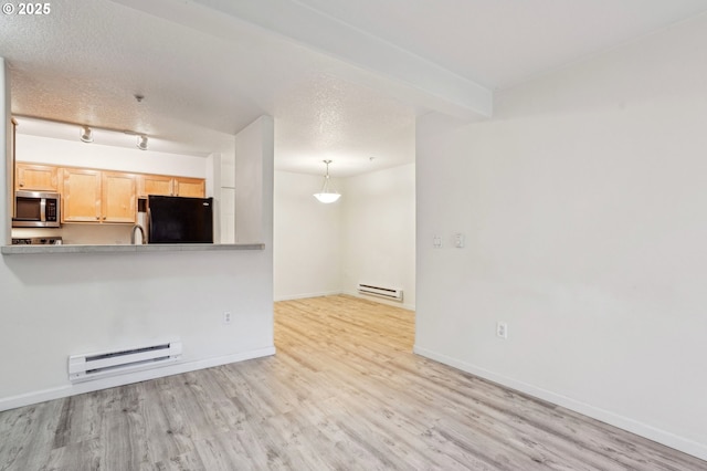 unfurnished living room featuring baseboard heating, light hardwood / wood-style floors, and a textured ceiling