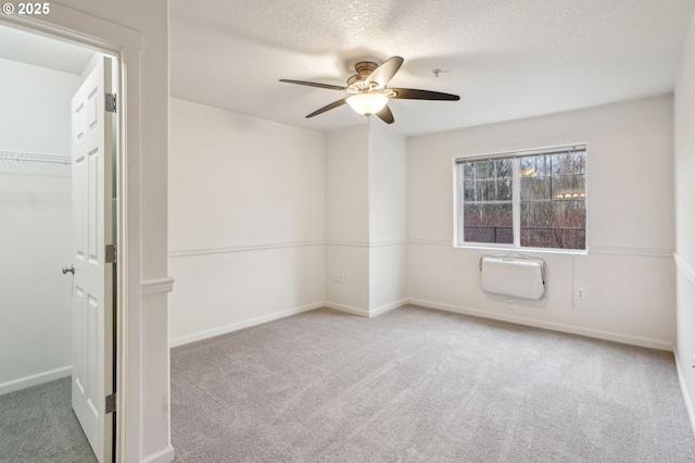 carpeted empty room featuring ceiling fan and a textured ceiling