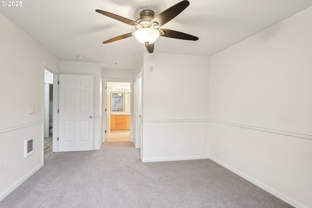 spare room with light carpet and a textured ceiling