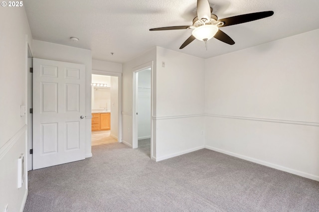 carpeted empty room featuring ceiling fan and a textured ceiling